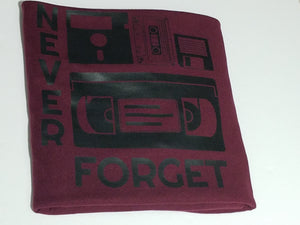 Black ink Never Forget design with cassette, VHS, and retro icons on burgundy unisex short sleeve Chozzen Few cotton T-shirt